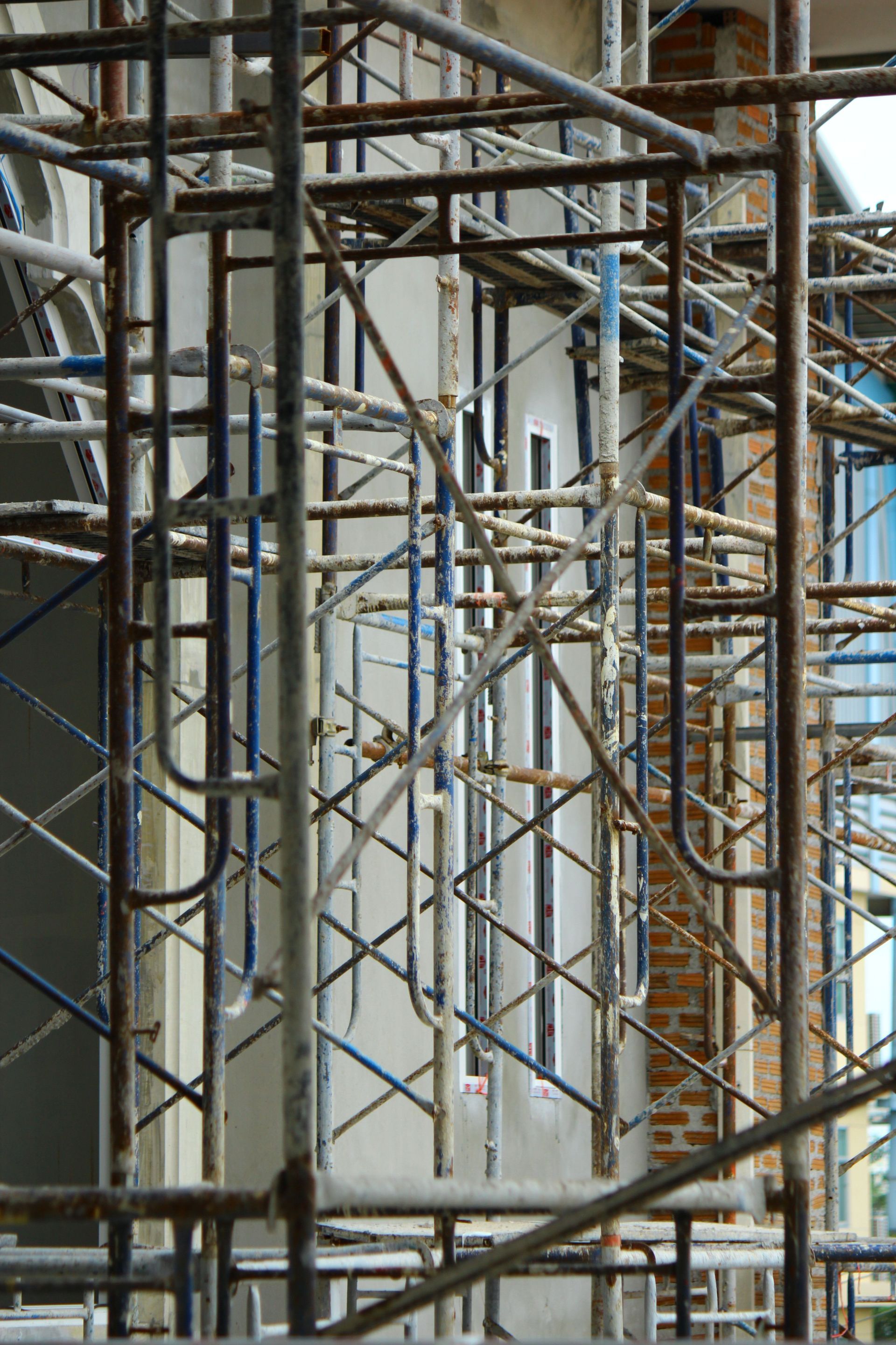 Construction worker in PPE with a camera and cranes in background