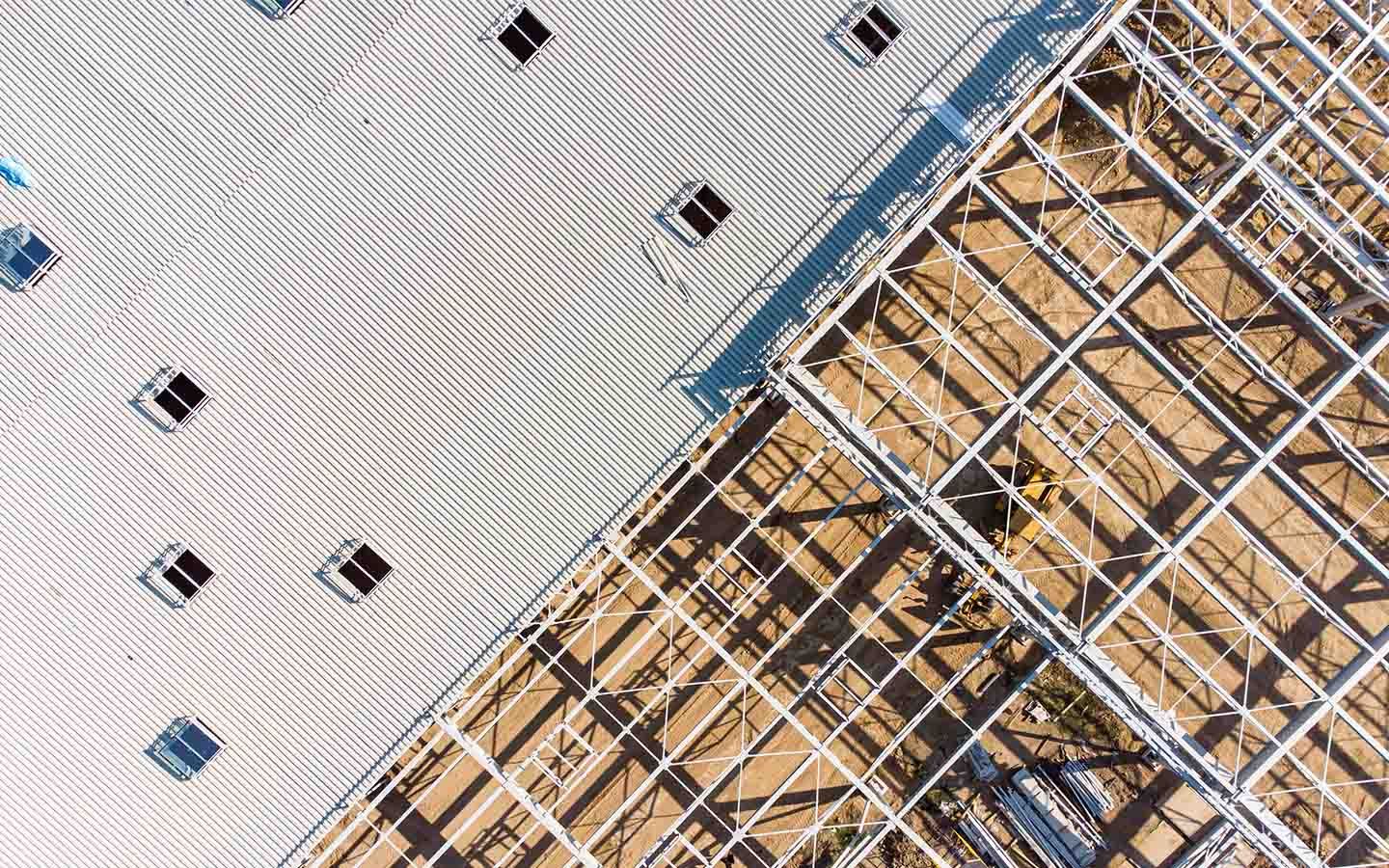 Diagonal view of a white wall beside a metal construction scaffold with blue trim