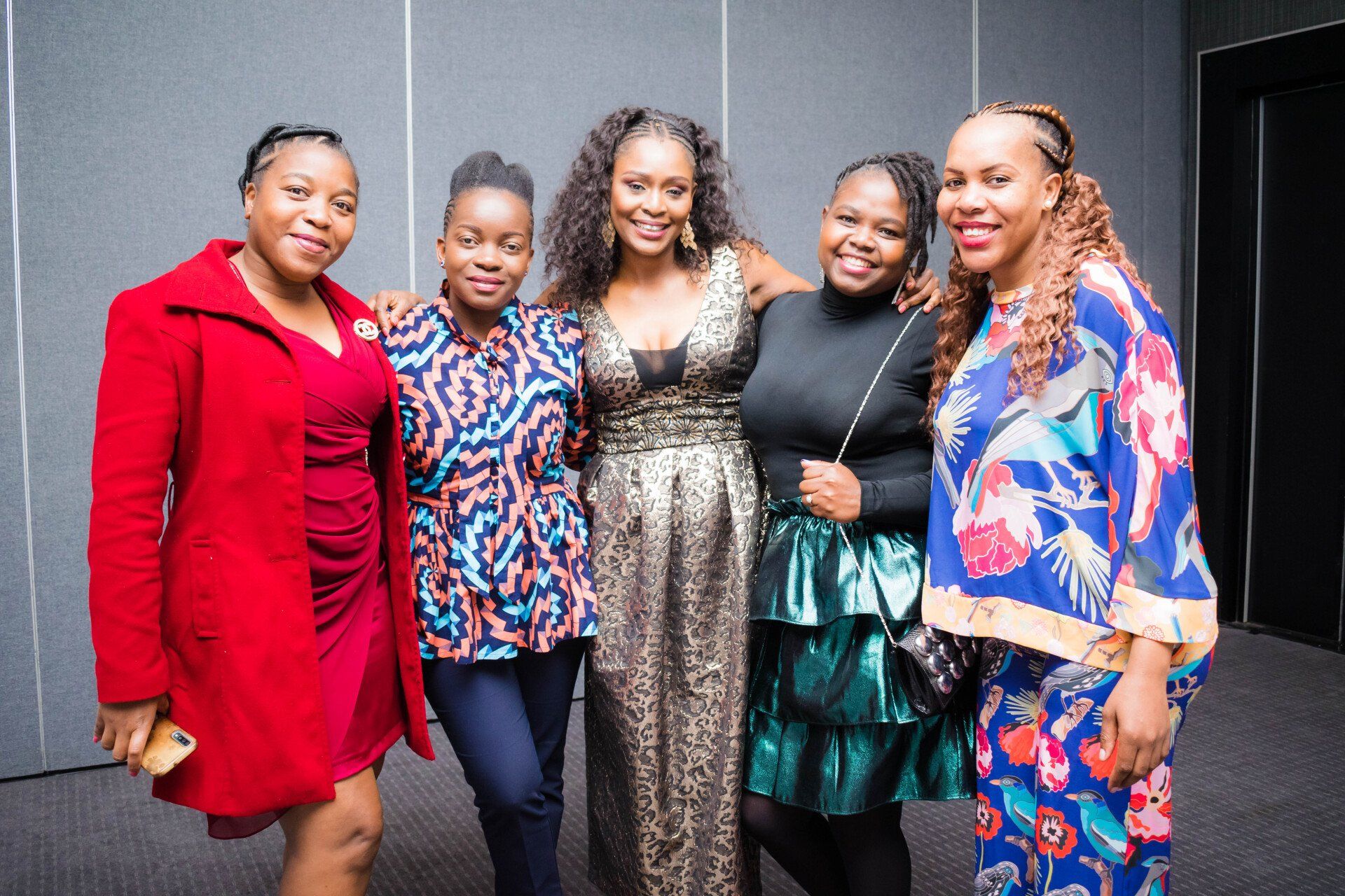 group of professional woman posing for a photo at an evening event