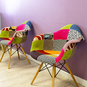 two colourful reception chairs in room with lilac walls