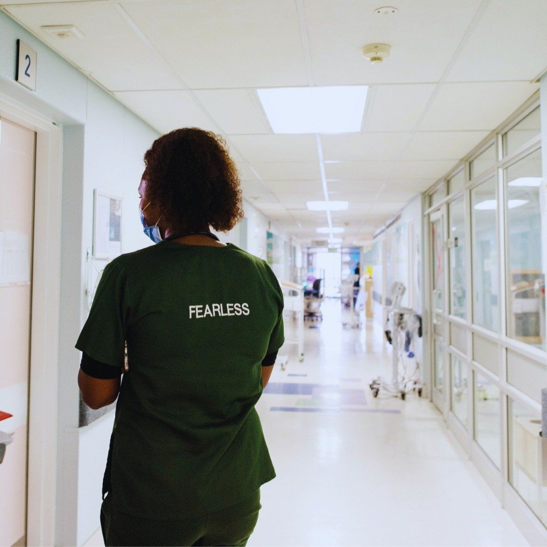 female doctor walking down hospital ward hallway
