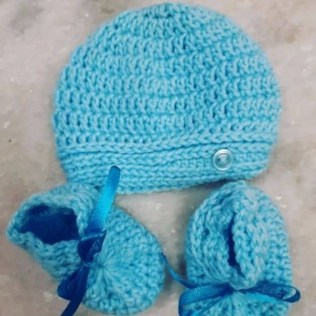 blue knitted beanie and booties for a baby