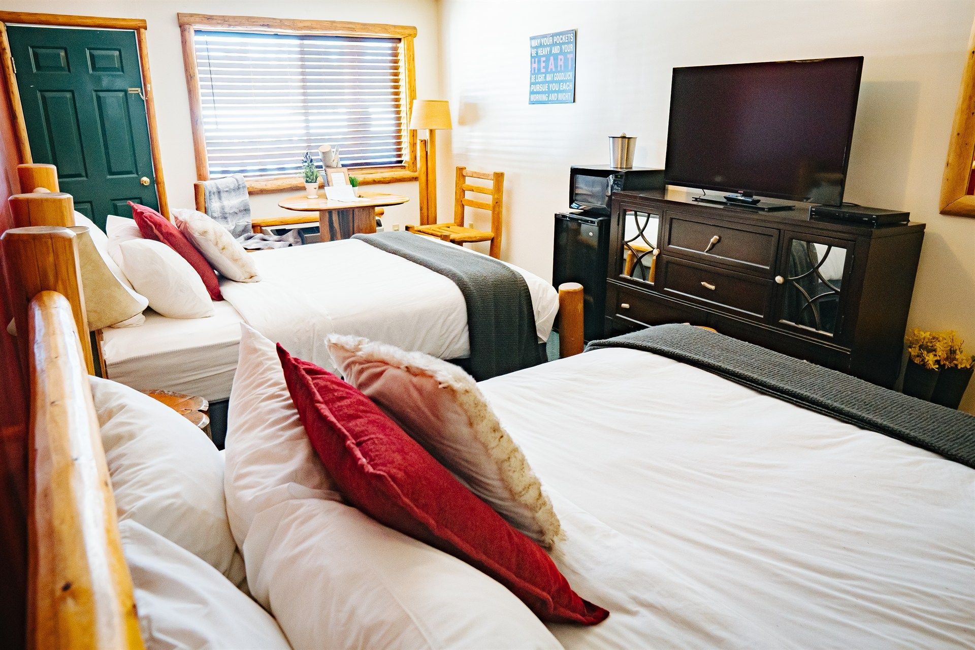 A hotel room with two beds and a flat screen tv.