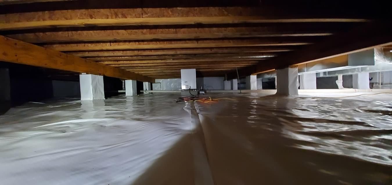 Floodwater flowing through a low basement with exposed wooden beams overhead.