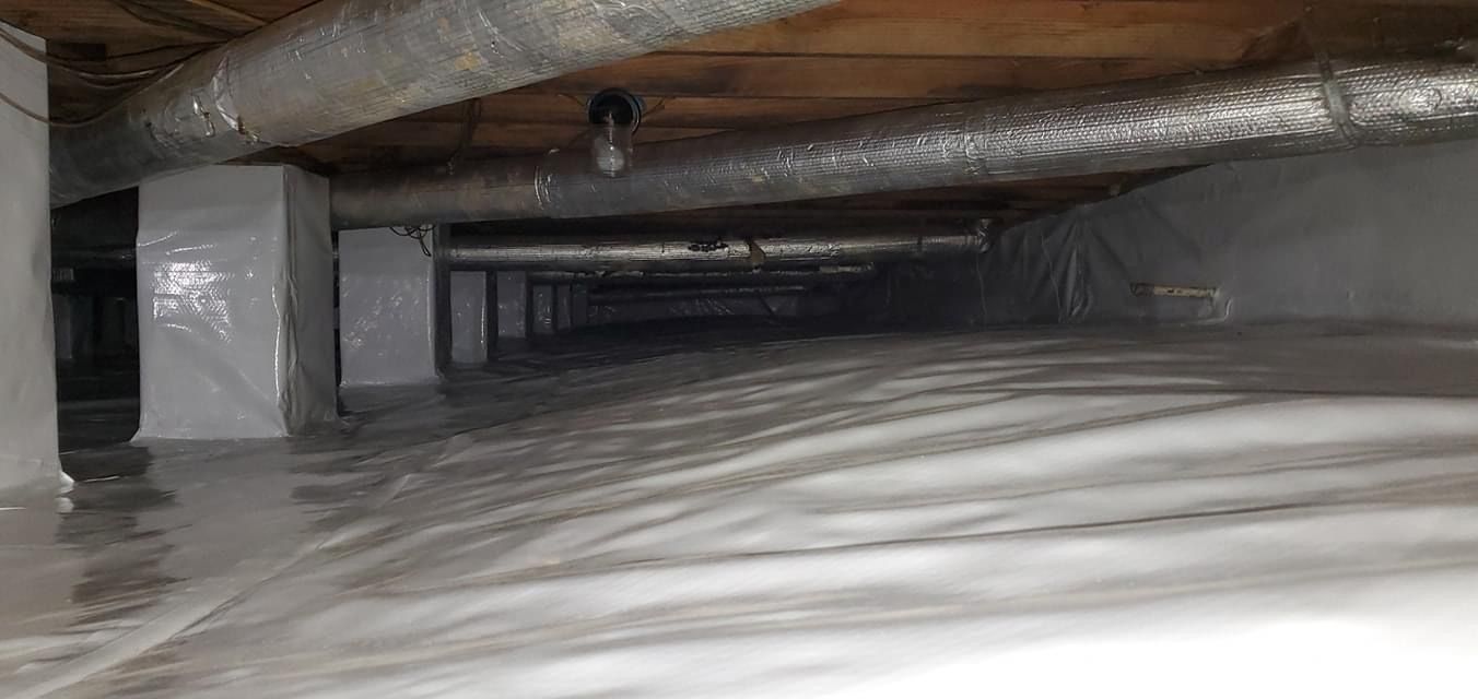 Inside a narrow metal duct, showing wrapped insulation and dark ventilation space.