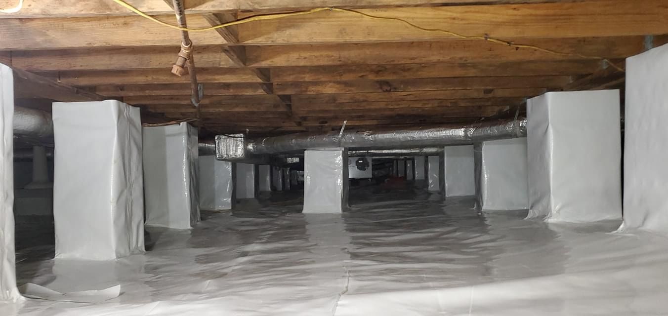 Empty industrial basement with concrete pillars and low wooden ceiling, lit dimly