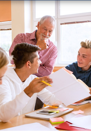 A group of people are sitting around a table looking at papers.