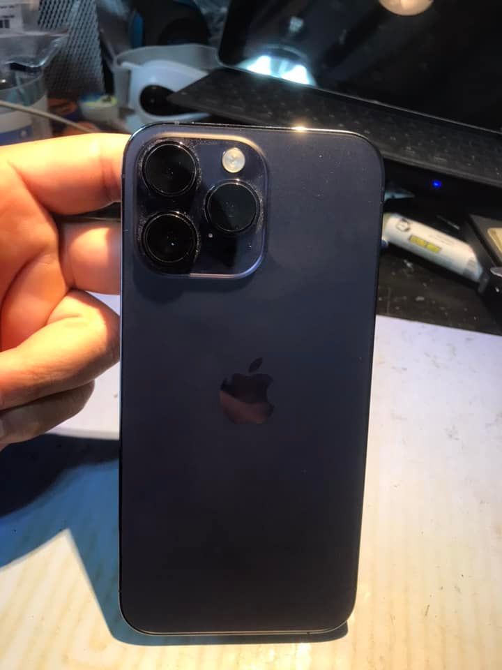 A person is holding a black iPhone in their hand.