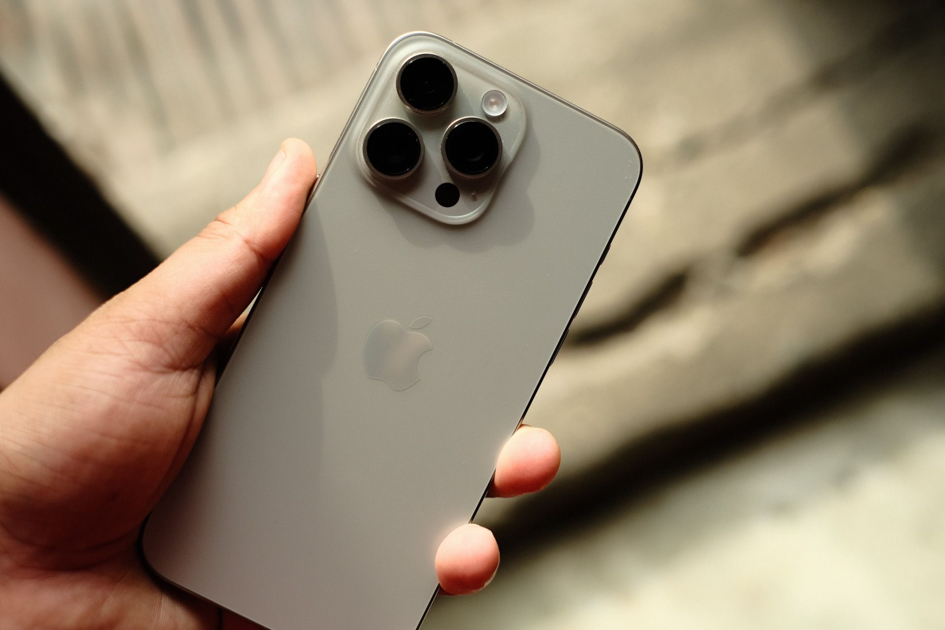 A person is holding a gray iPhone in their hand.