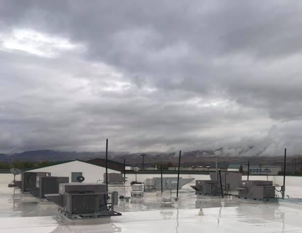 A rooftop of a building with a cloudy sky in the background.
