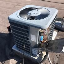 A large air conditioner is sitting on top of a roof.