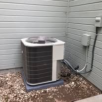 An air conditioner is sitting in the corner of a house.