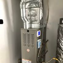 A furnace is sitting in a room next to a wall.