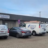 A row of cars and vans parked in front of a building.