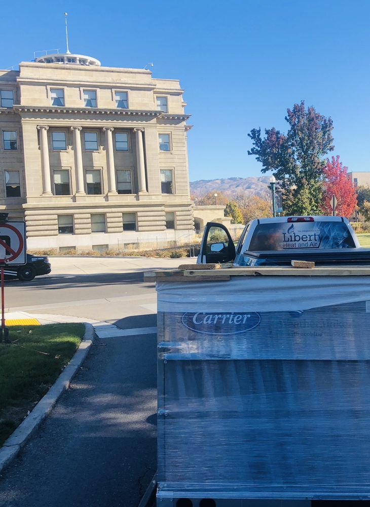 A carrier truck is parked in front of a large building