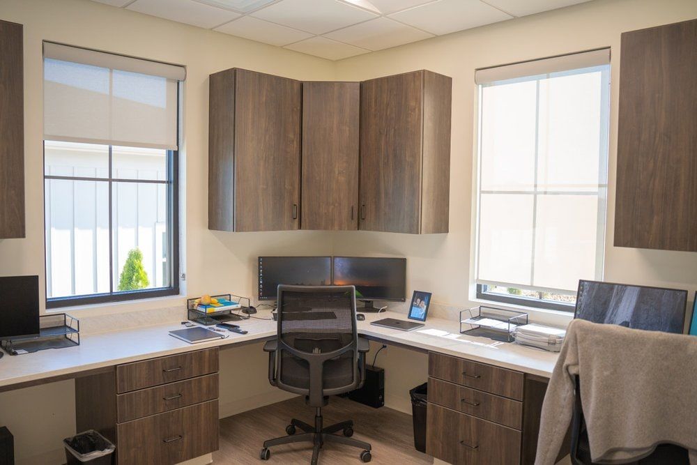 A small office with two desks and a chair.