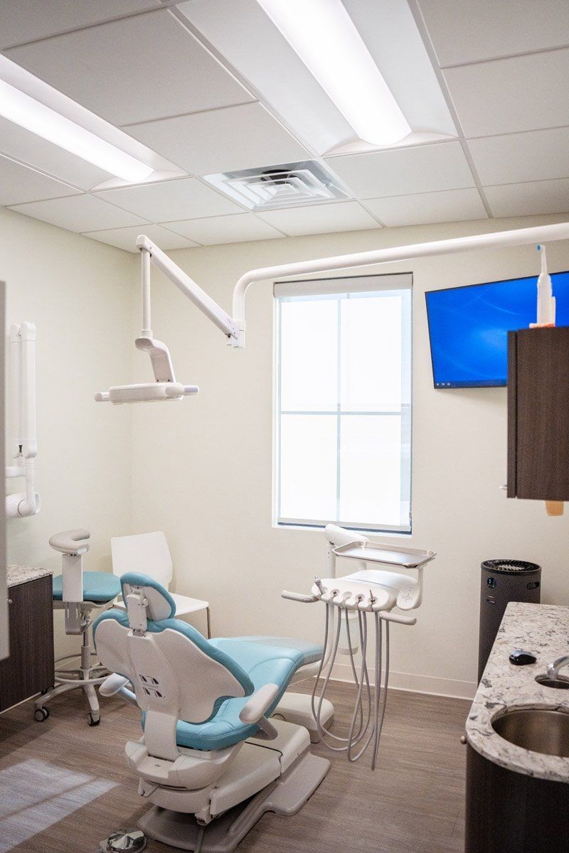 A dental office with a dental chair and a sink.