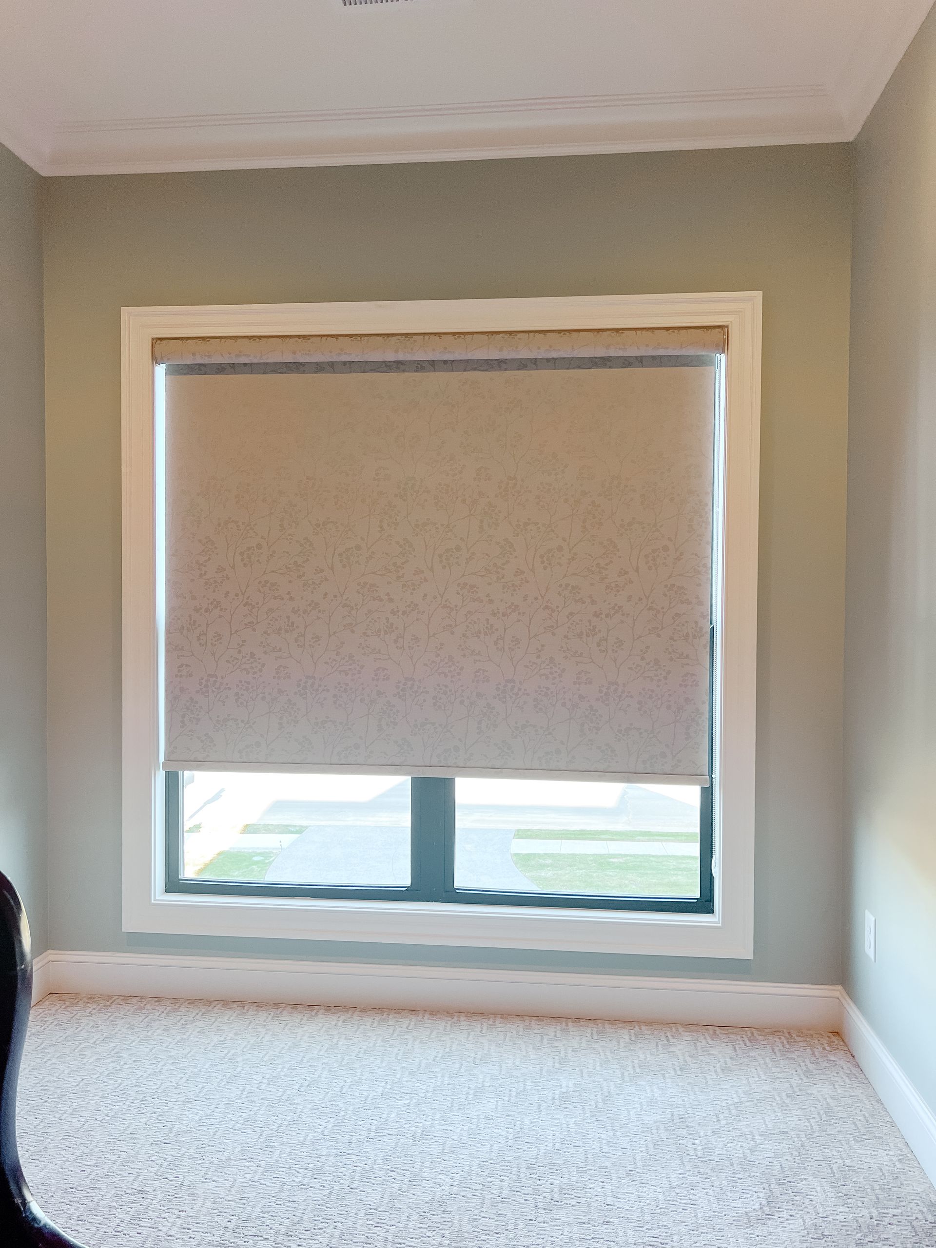 A room with a window and natural woven shade.