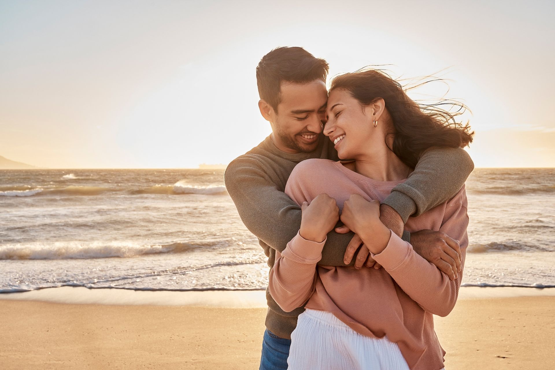 Couple hugging on a beach.