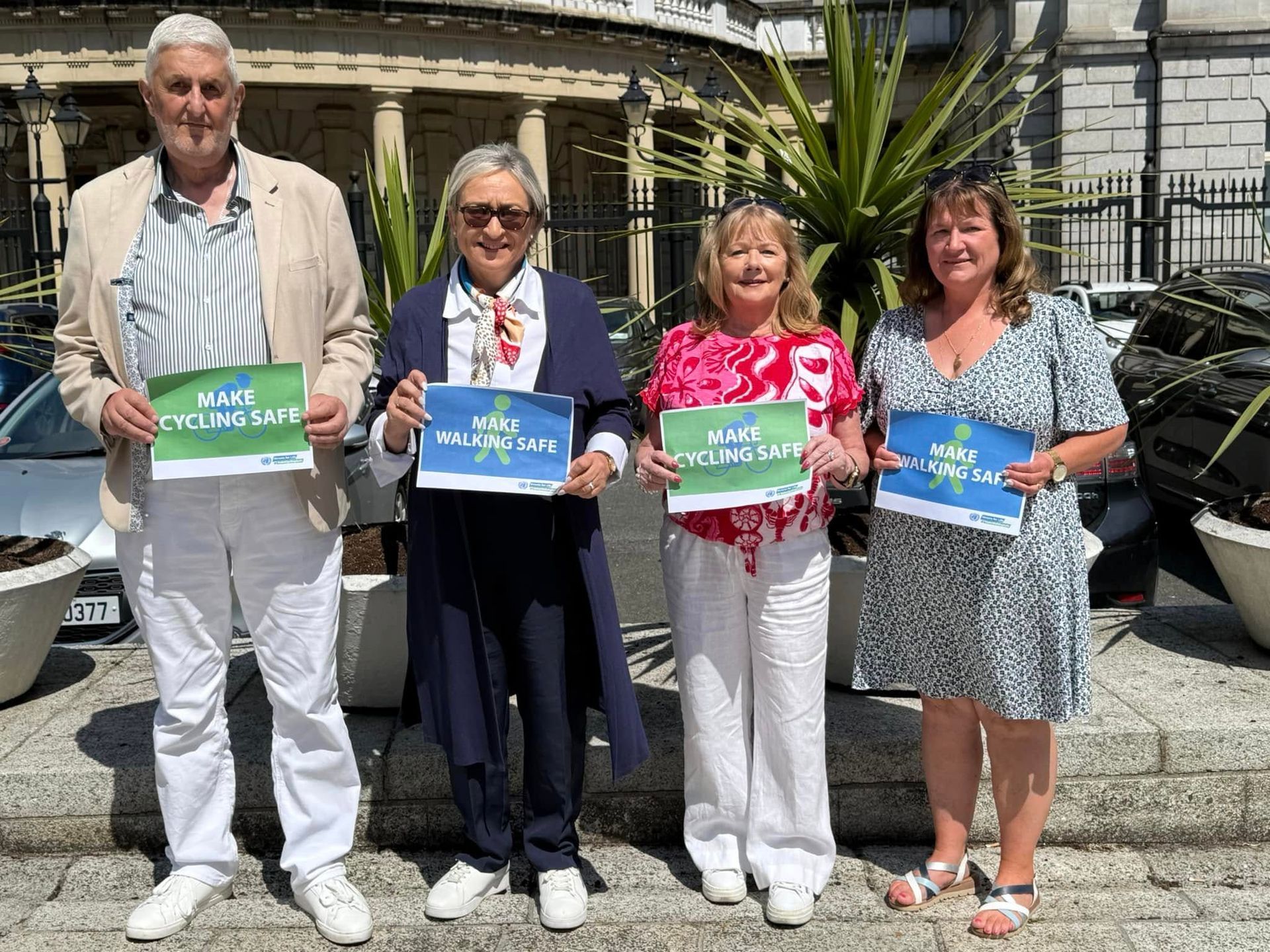A group of people standing next to each other holding signs.