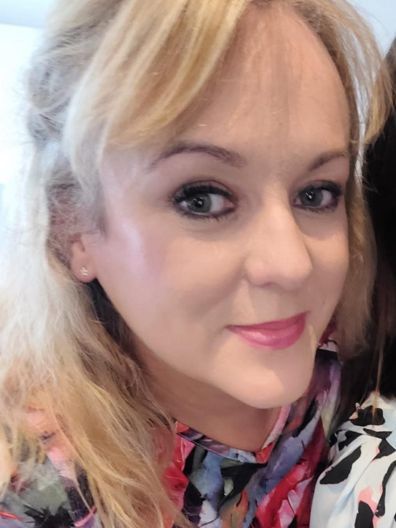 A close up of a woman 's face with a floral shirt on