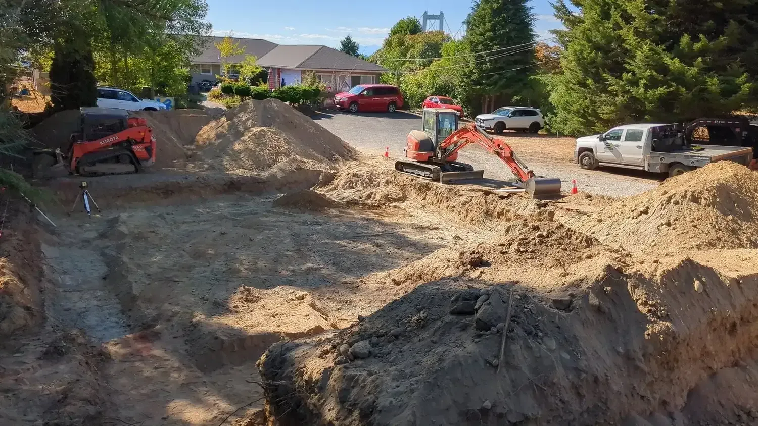 A large pile of dirt is being excavated in front of a house.