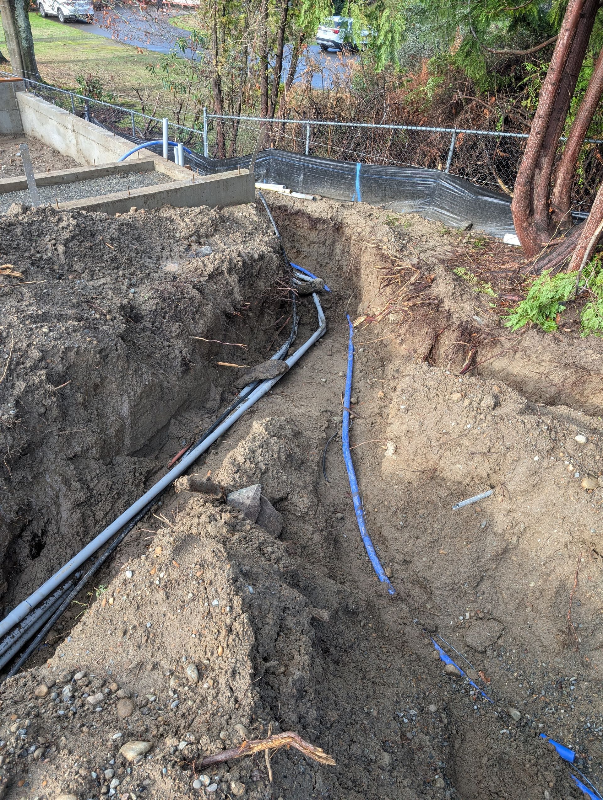 A hole in the ground with a bunch of wires coming out of it.