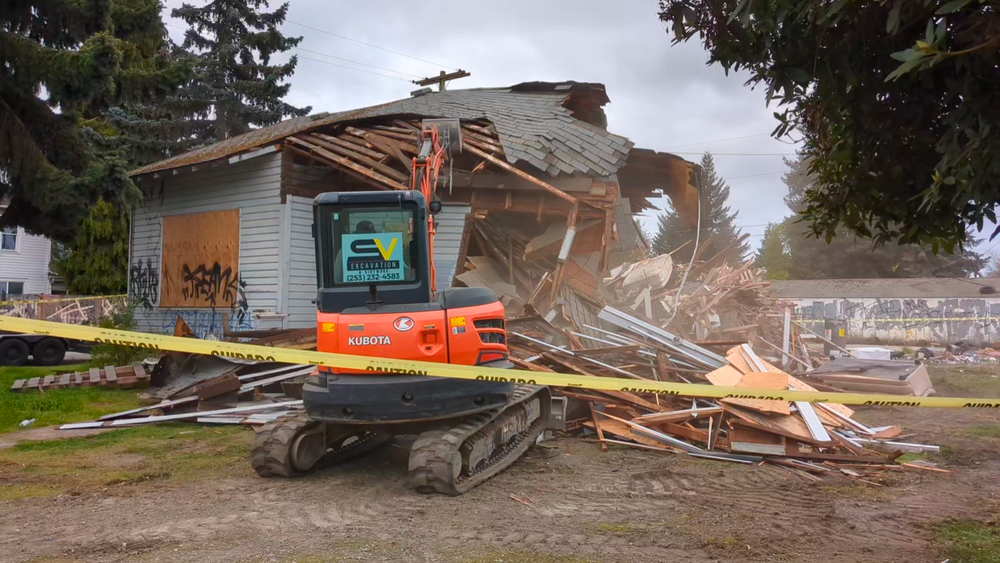 A house is being demolished by a bulldozer.