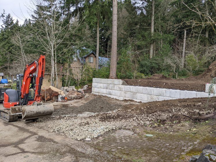 A small excavator is sitting in the middle of a dirt field.