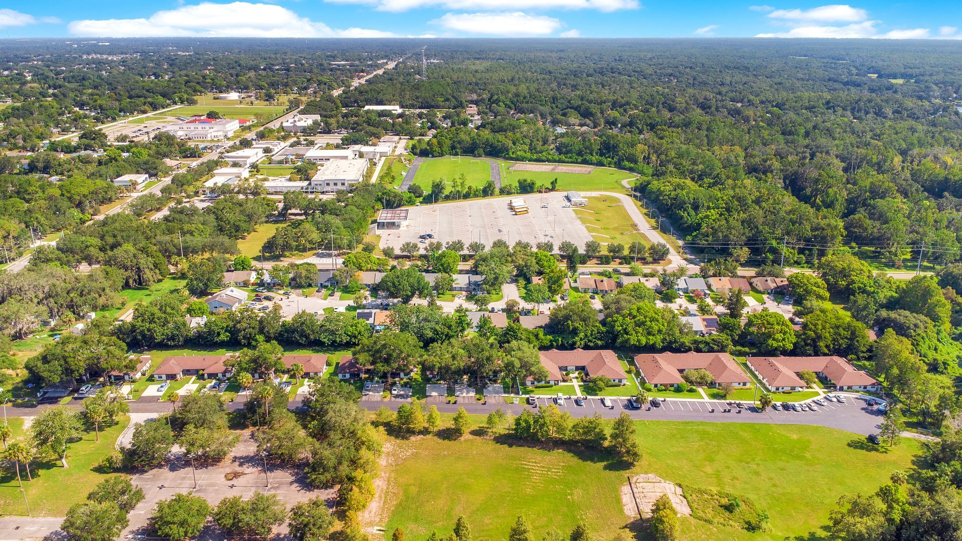 An aerial view of a residential area surrounded by trees and houses.