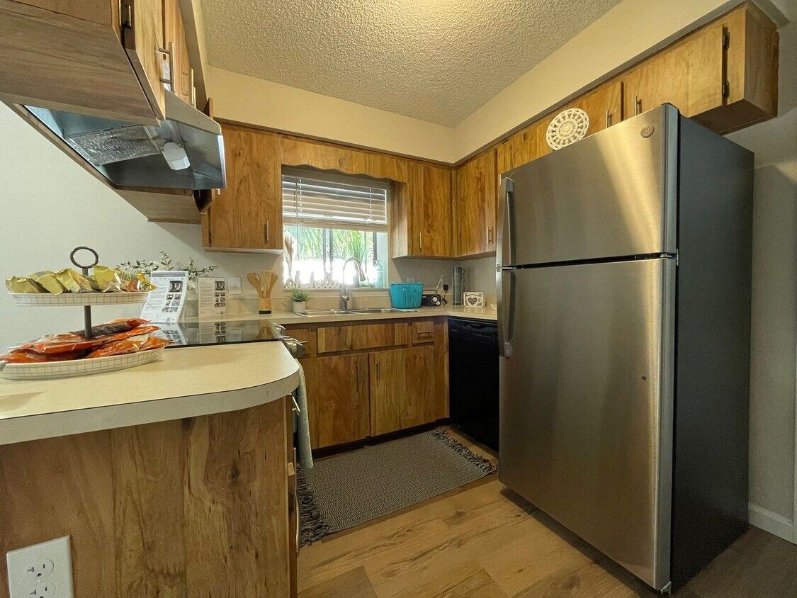 A kitchen with stainless steel appliances and wooden cabinets.