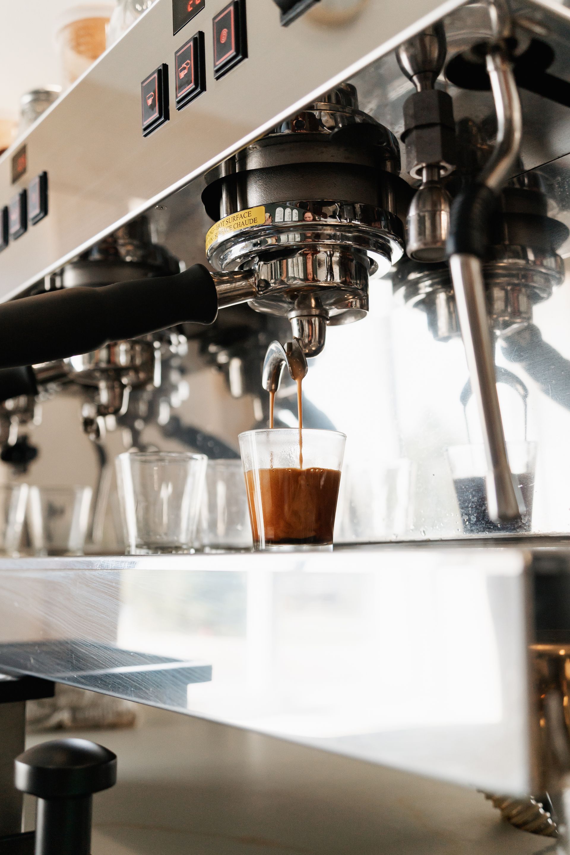 A woman wearing a white sweatshirt and blue jeans is standing in front of a building.