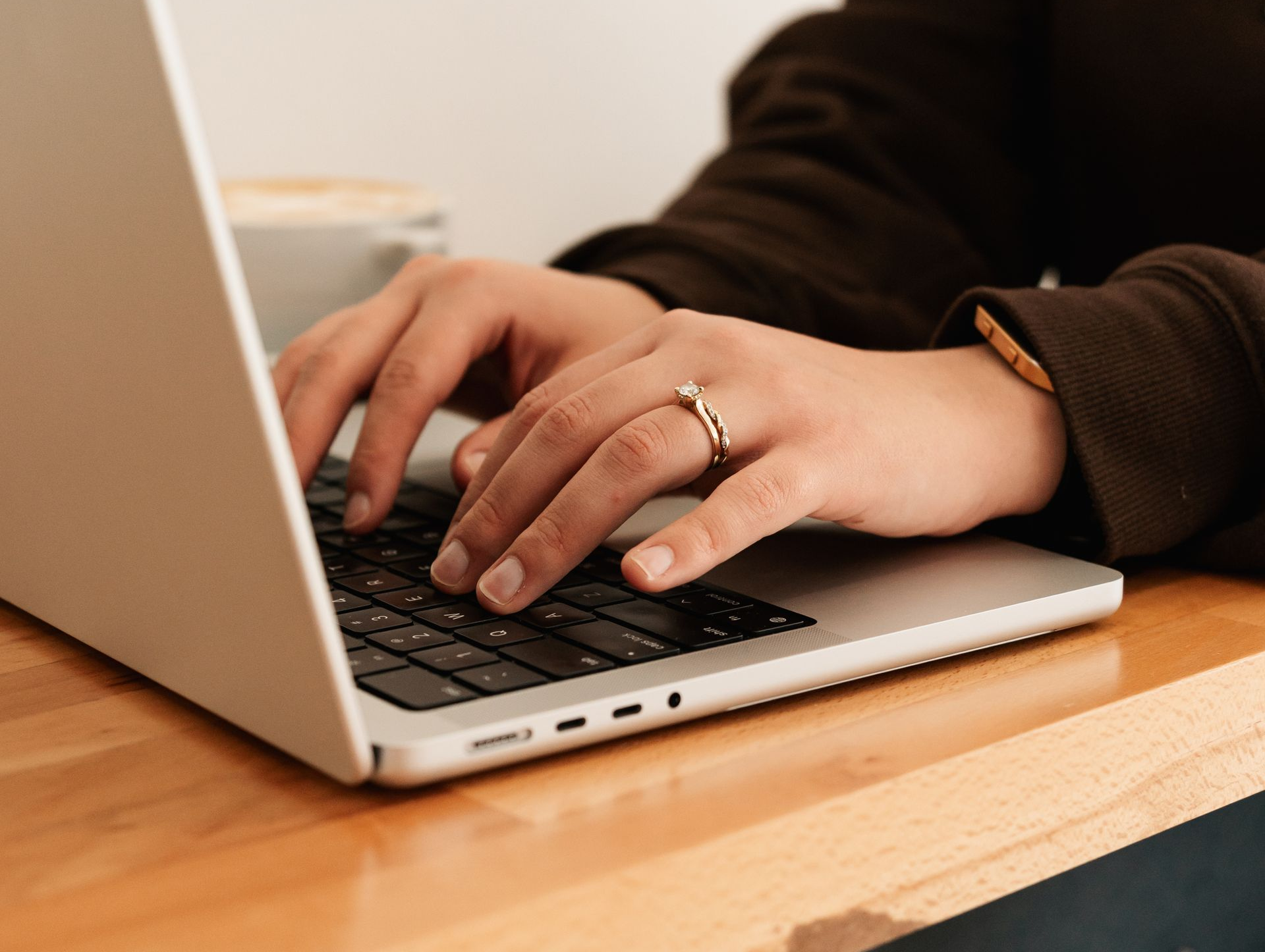 woman working remotely on laptop in coffee shop in Mansfield Ohio while drinking local specialty coffee from Impact Coffee Company