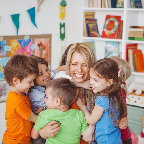 Kids Hugging Their Teacher — Kankakee, IL — Lasting Impressions Learning Centers