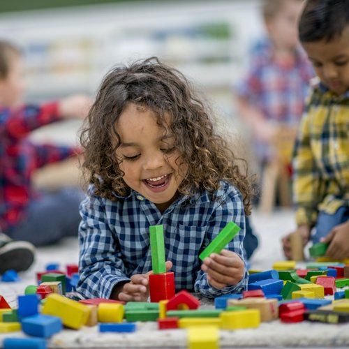 Happy Kid Playing With Shape Blocks — Kankakee, IL — Lasting Impressions Learning Centers