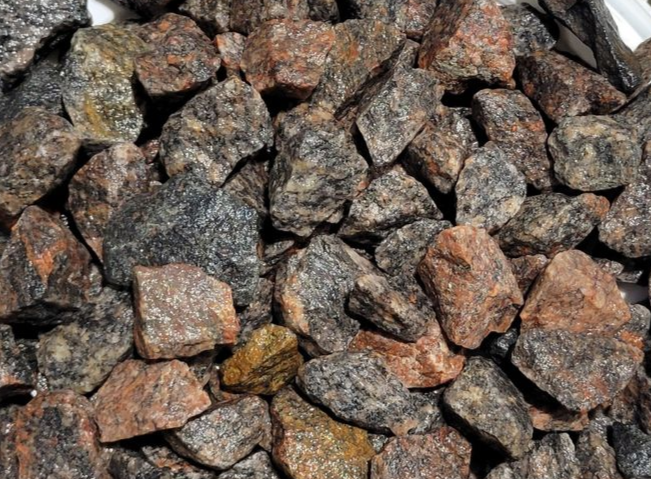 A pile of black gravel with a lot of rocks in it.