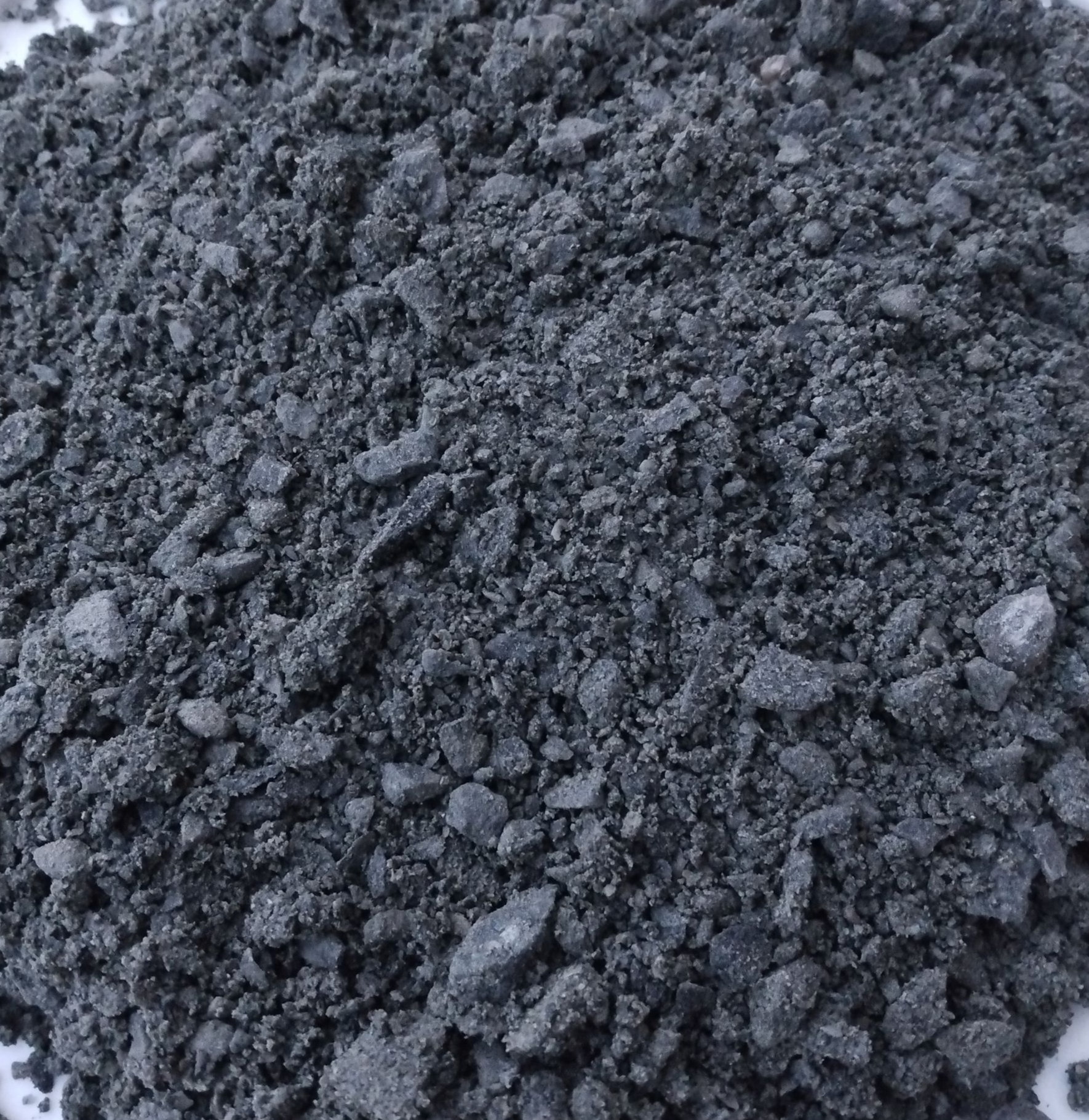 A white plate topped with a pile of black rocks.