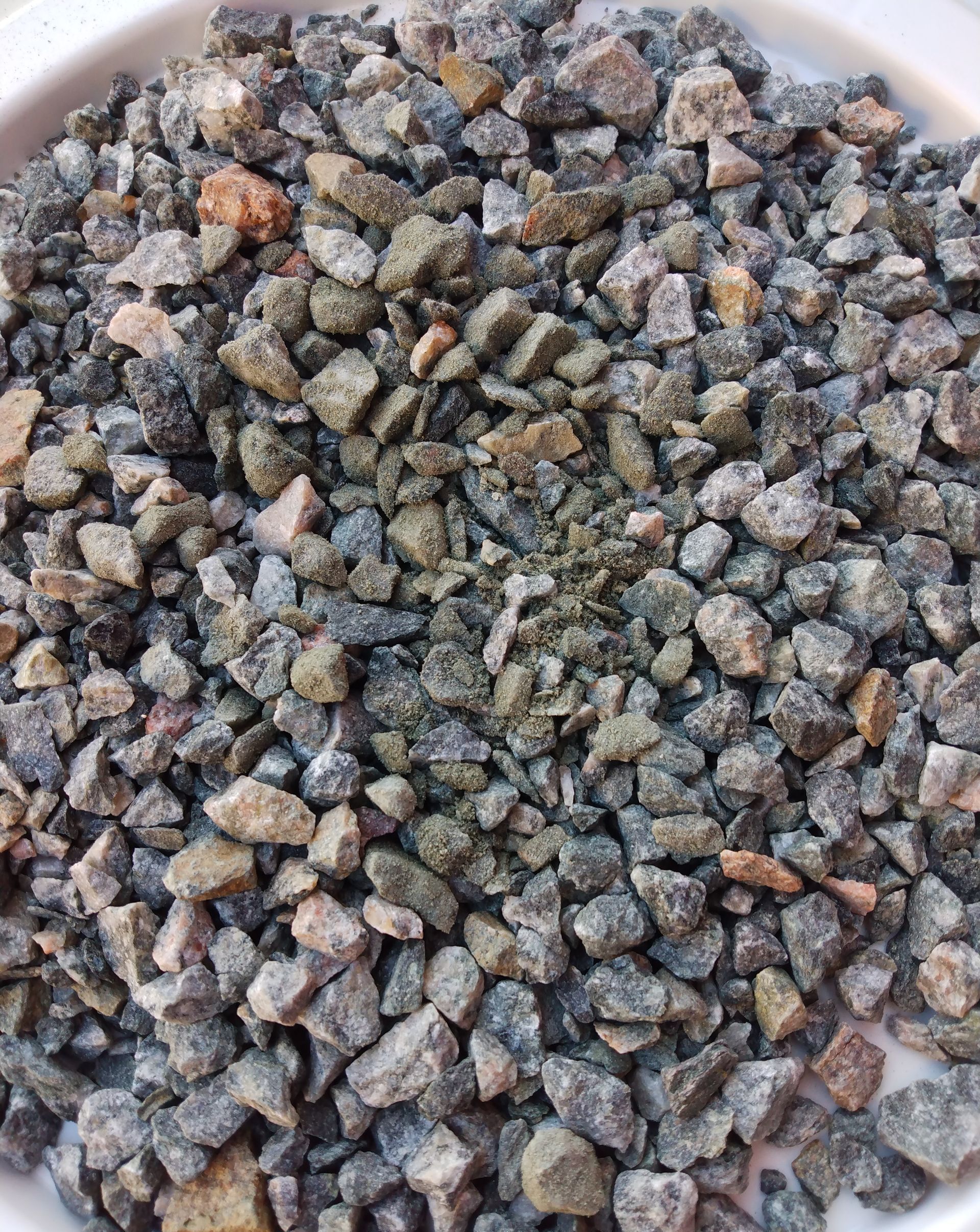 A pile of black gravel with a lot of rocks in it.