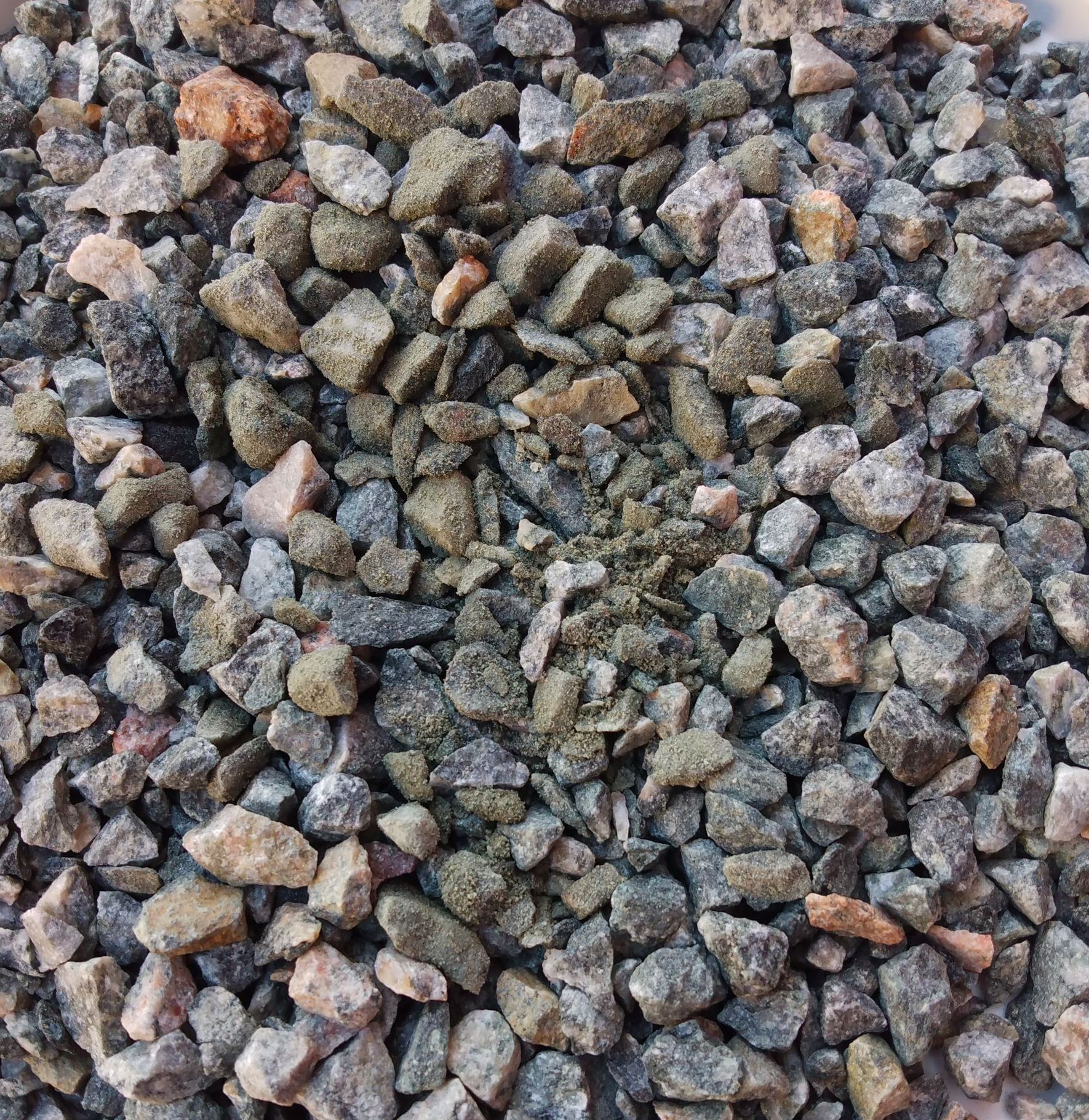 A pile of black gravel with a lot of rocks in it.