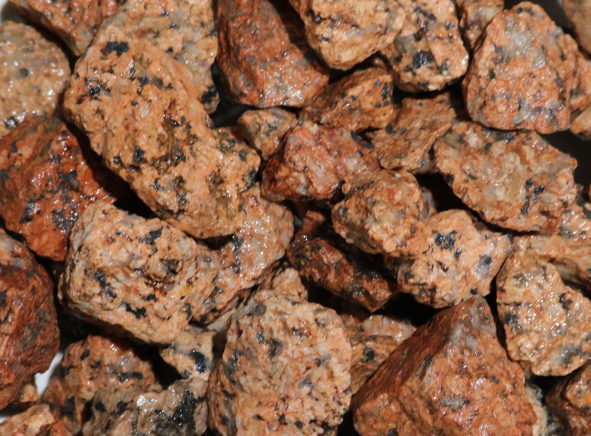A pile of rocks of different sizes and colors on a white plate.