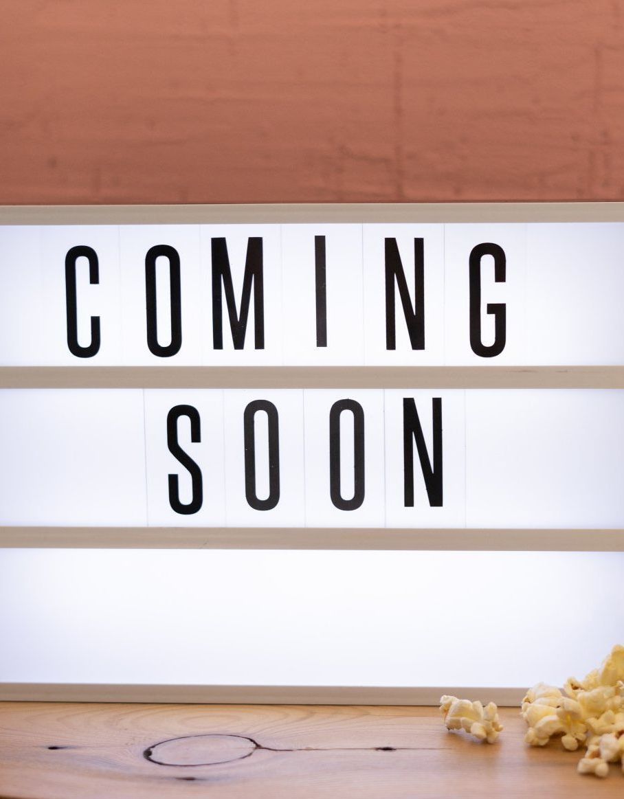 A light box that says `` coming soon '' next to a bowl of popcorn.