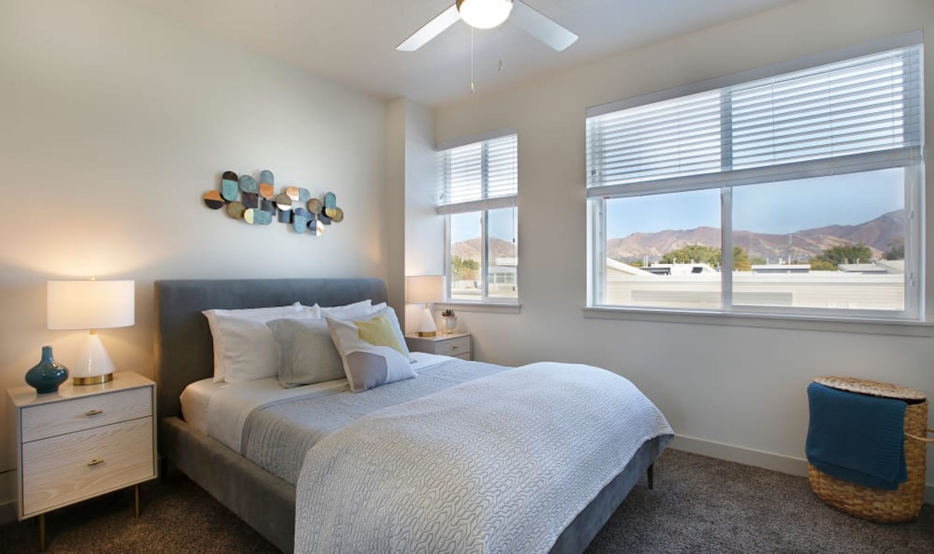 Bedroom with bed, nightstands, windows, decor, and mountain view.