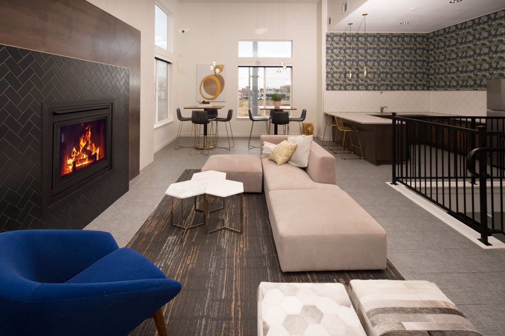 Modern lounge with fireplace, seating area, and kitchenette.