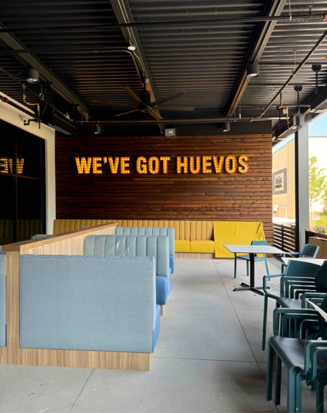 Restaurant interior with blue booths, yellow benches, and 