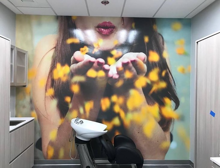Woman blowing golden confetti, salon wash station.