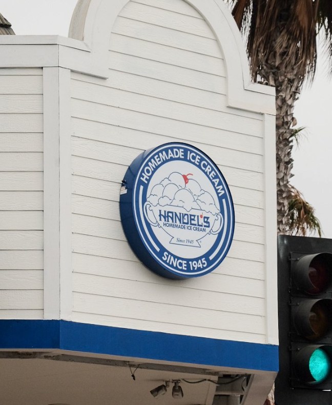 Handel's Homemade Ice Cream sign, blue and white circular logo on white building, green traffic light.