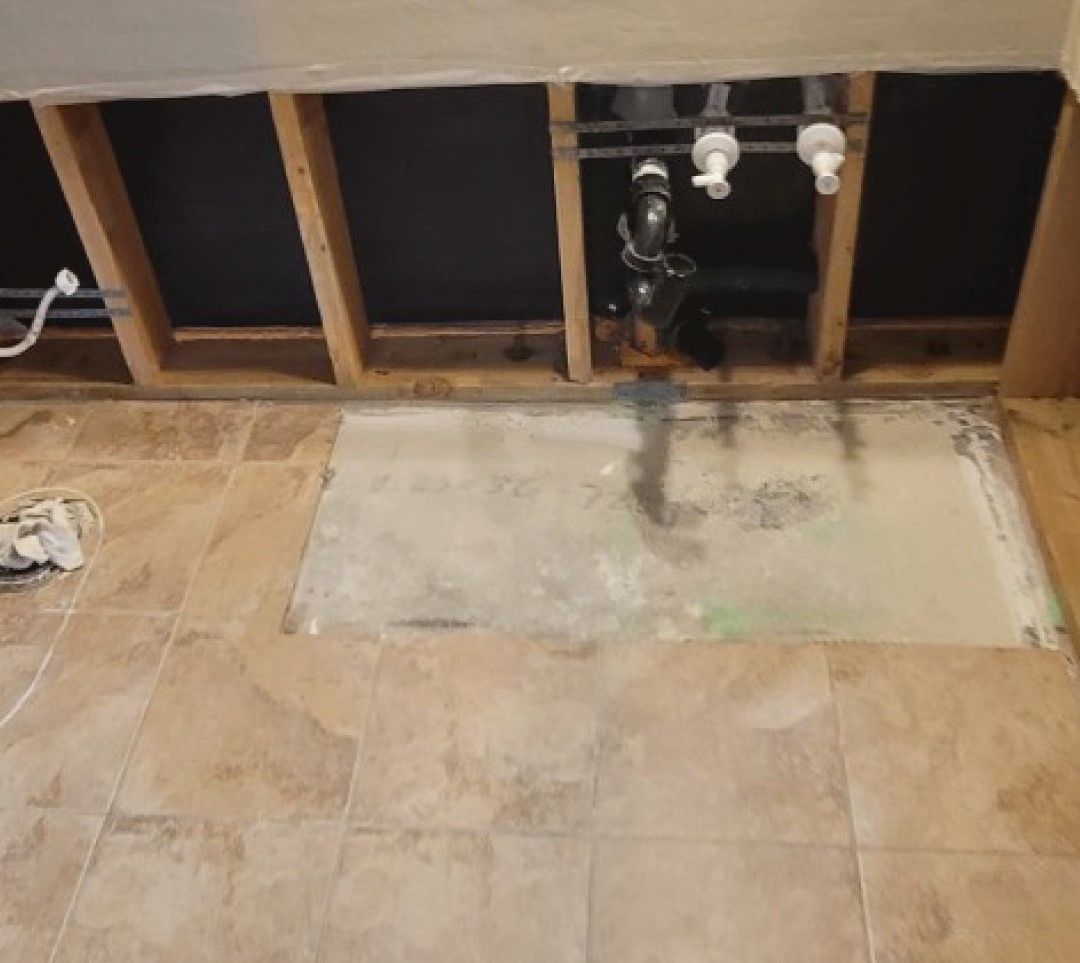 A bathroom sink is being remodeled with a hole in the floor