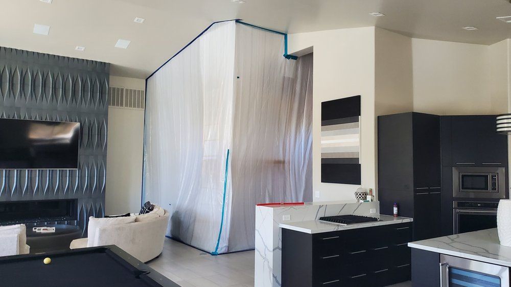 A living room with a pool table and a kitchen