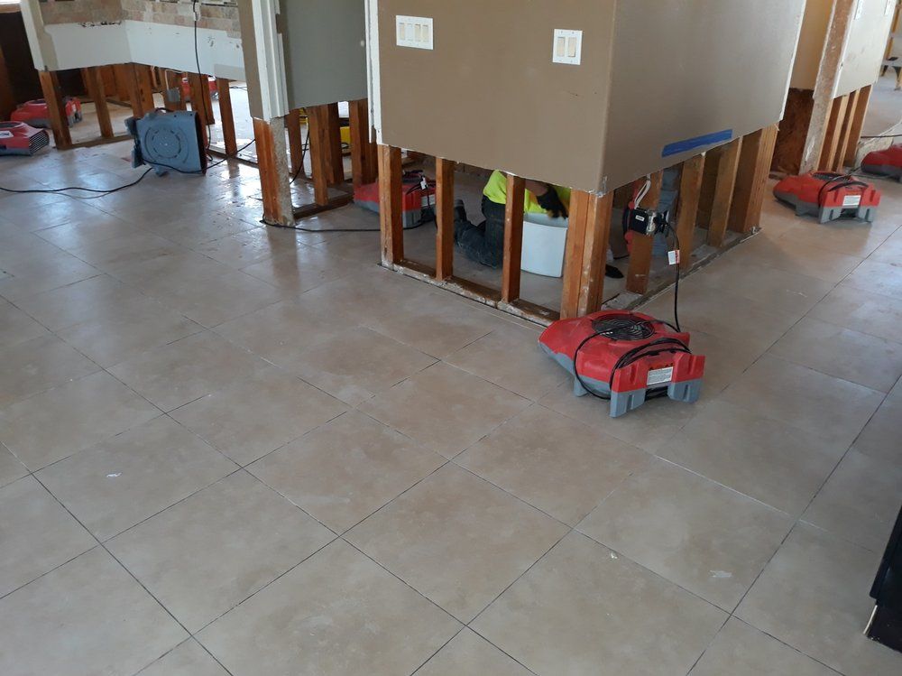 A room with a tiled floor and a vacuum cleaner on the floor.