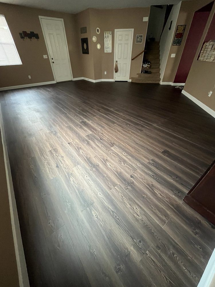 A living room with hardwood floors and a staircase.